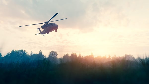 Militär och en helikopter som flyger över skogen